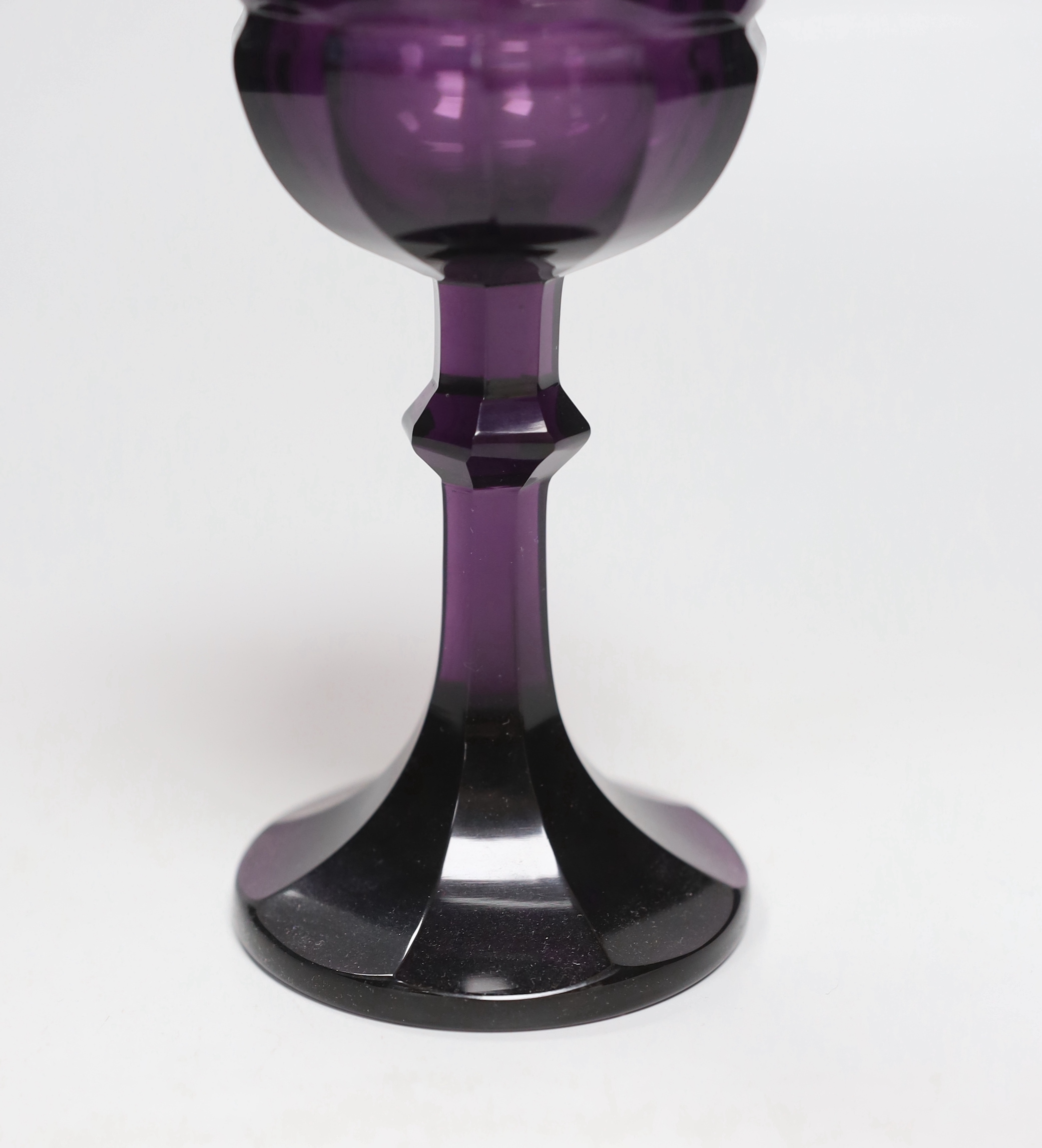 A Bohemian amethyst goblet, seemingly cut from a single piece of glass in a facetted form with a knopped stem cascading to a facetted foot with flat base and ground pontil, 17.5cm, weight 488 grams